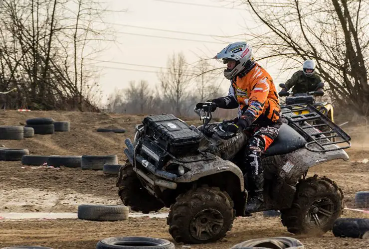 ATV riders on the verge of overturning and having an accident due to a too sharp turn
