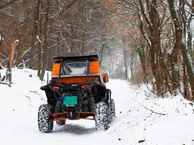 UTV driving in snow, winter kitted with windshield and cabin cover